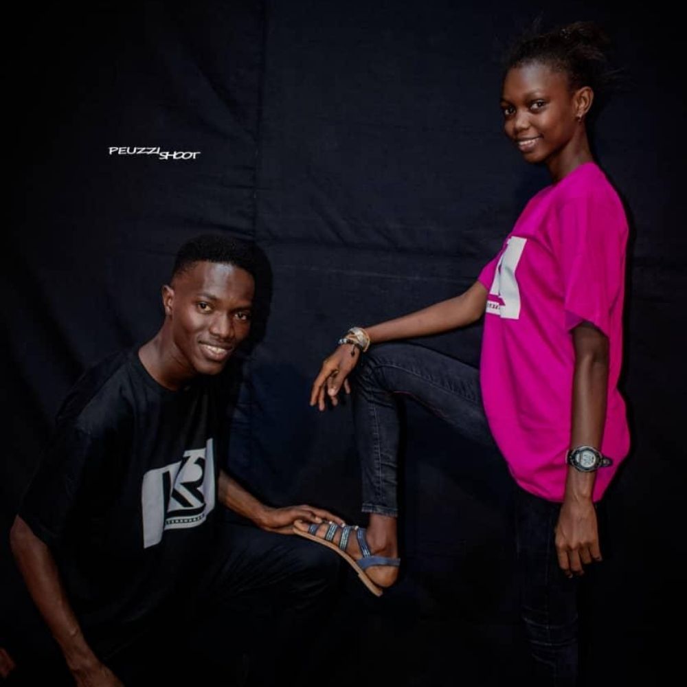 Ein junger Mann und eine junge Frau mit farbigen T-Shirts posieren für die Kamera.