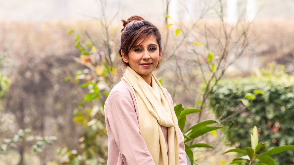 ایک نوجوان خاتون کیمرے میں دیکھ رہی ہیں۔