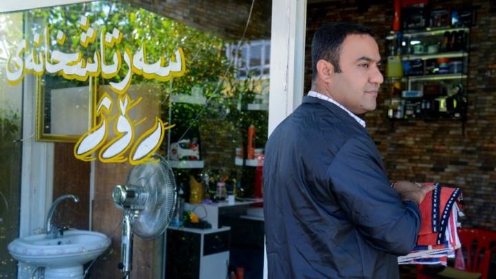 A man stands in front of a hairdressing salon. A man stands in front of a hairdressing salon.