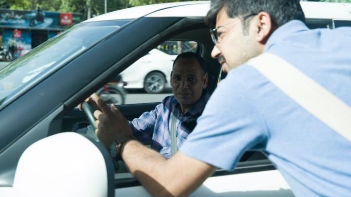 Ein Autofahrer unterhält sich mit einem Mann durch das Fenster.