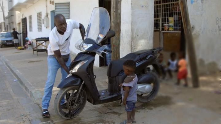 Ein Mann wäscht ein Motorrad.