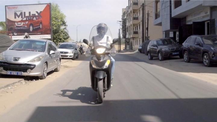 Ein Mann fährt auf einem Motorrad eine Straße entlang.