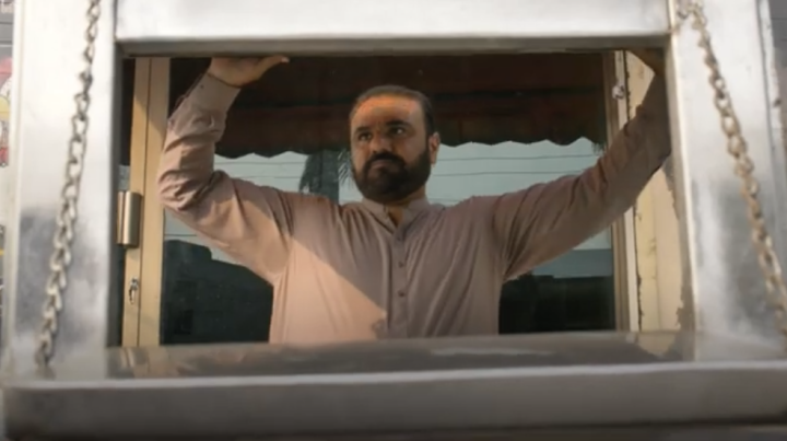 Ein Mann öffnet das Fenster eines Imbisswagens.